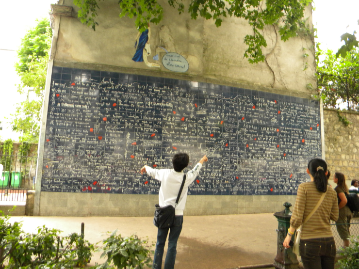 Place des Abbesse, tourists examining a plaque with "I love you" written in 311 languages