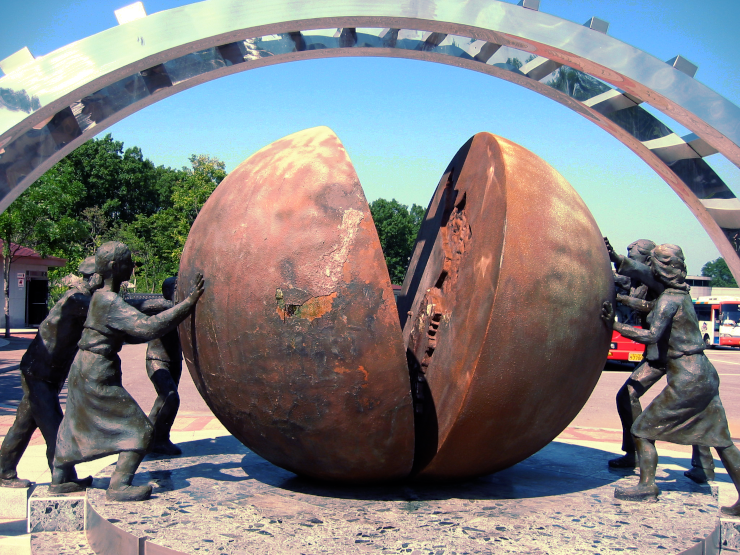 A monument featuring children pushing two hemispheres into a globe