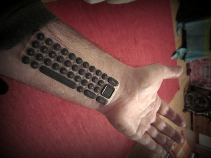 A hairy arm with a QWERTY keyboard "embedded" into it