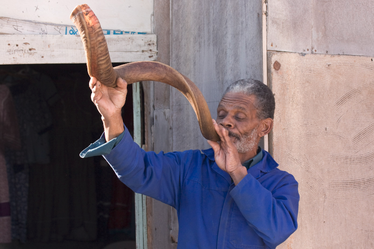 A Nama man playing a traditional greeting