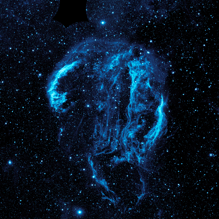 Wispy tendrils of hot dust and gas glow brightly in this ultraviolet image of the Cygnus Loop nebula, taken by NASA Galaxy Evolution Explorer