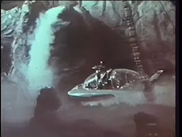 A shoddy-looking science fiction boat sailing through caves