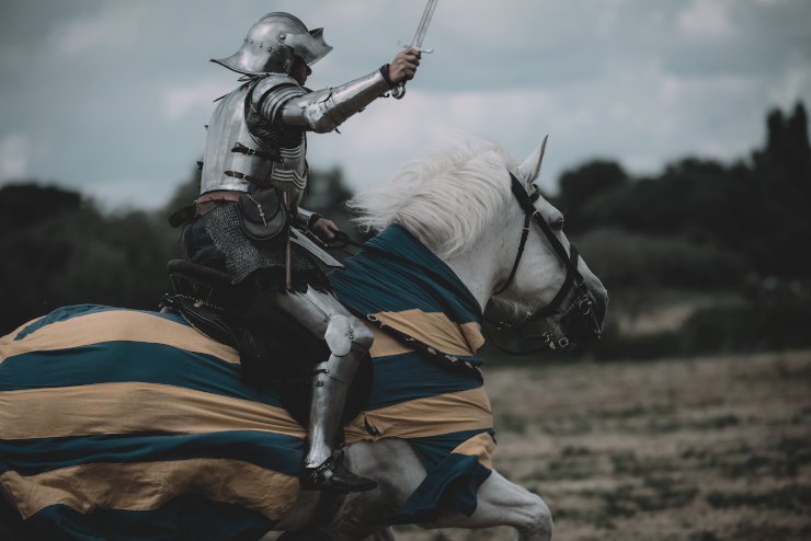 A knight riding on a horse, with sword drawn