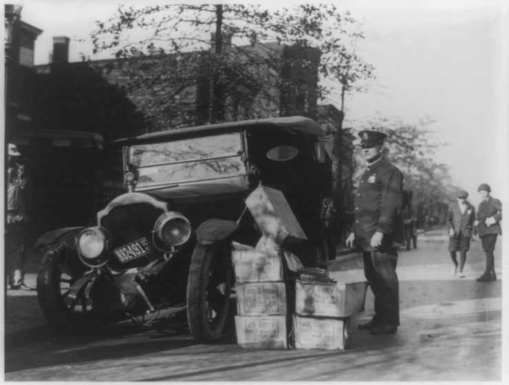 A police officer confiscating alcohol from a 1922 automotive accident